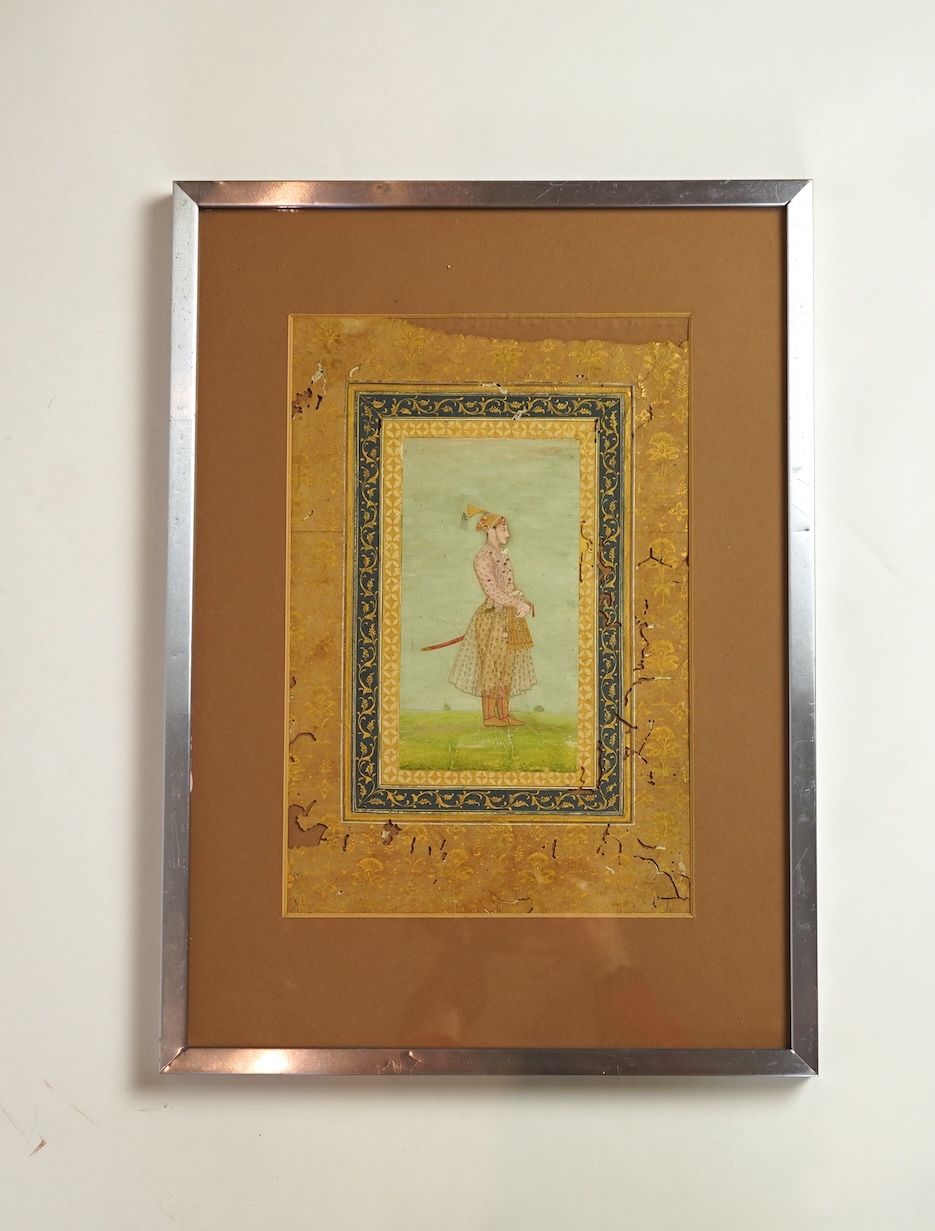 Mogul (Mughal) School , Profile Portrait of a Mogul dignitary, possibly Shah Jahan (1592-1666), full length, wearing court attire and a sword, standing in a landscape, watercolour miniature, 31cm x 20.5cm including borde